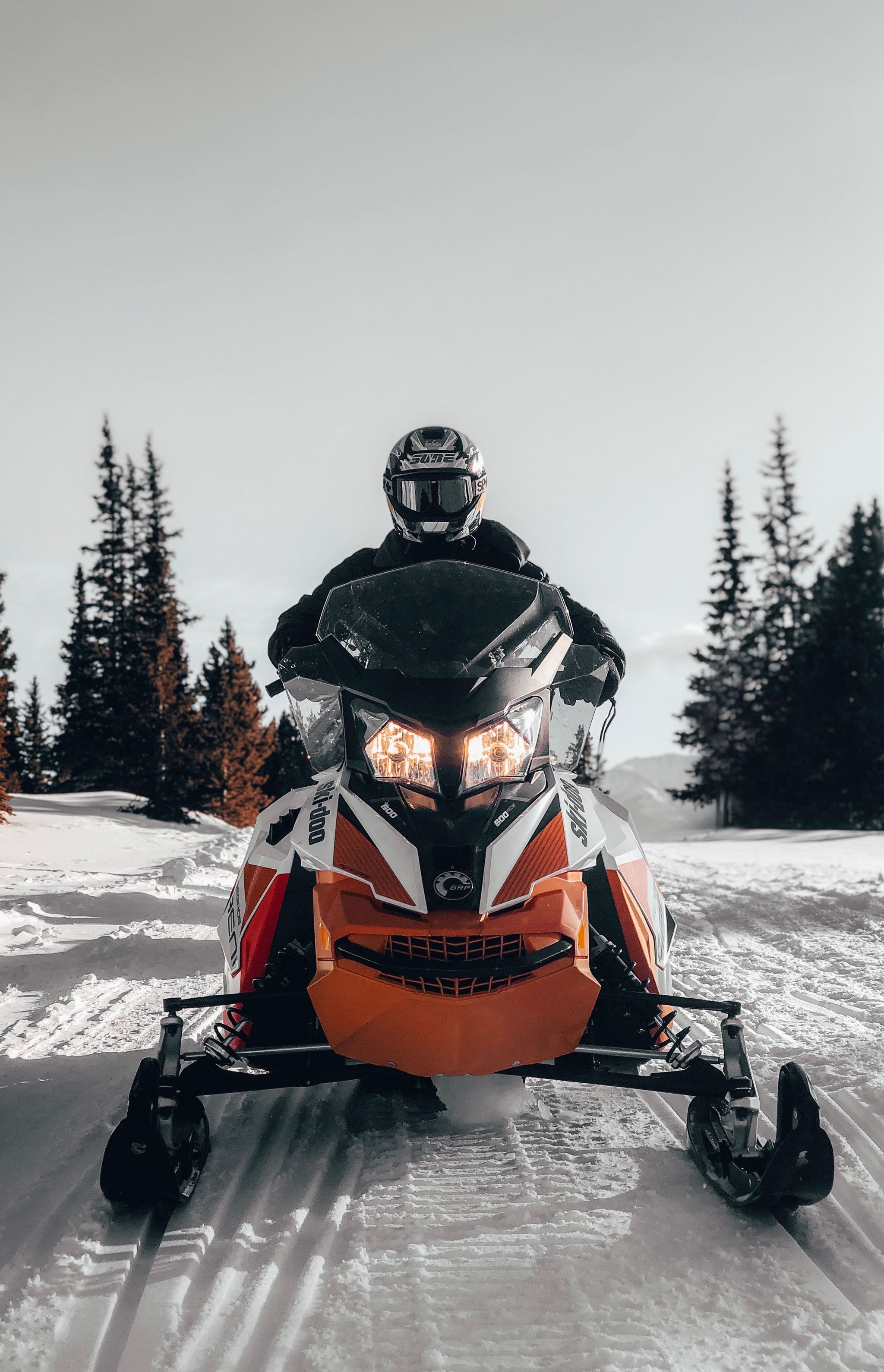 Un homme pilotant une motoneige dans un grand champ enneigé